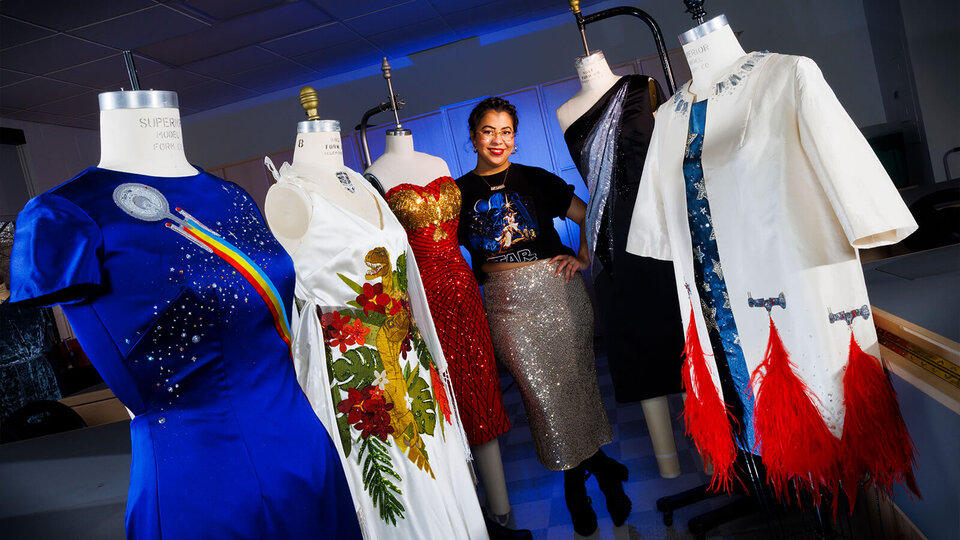 Woman standing among dress forms