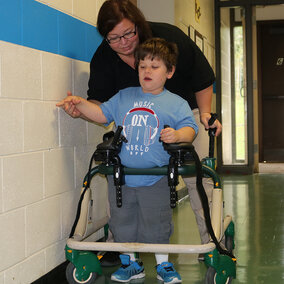 Woman helping a disabled child.