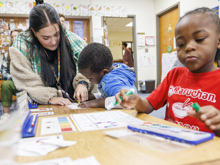Crandall Blake helps a student in her kindergarten classroom during her student teaching