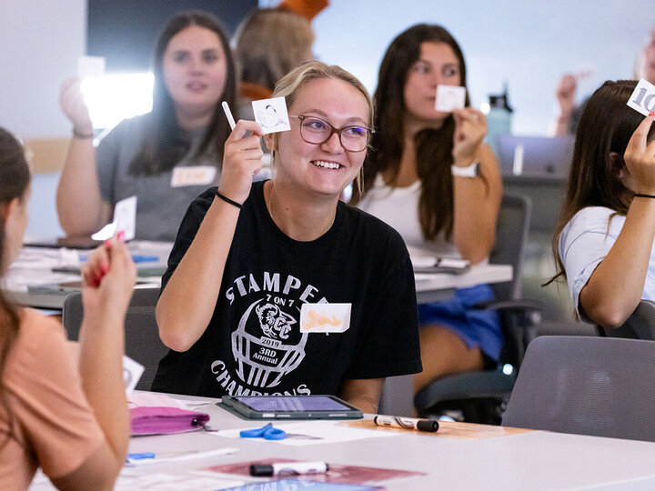 student in literacy class hold up slips of paper