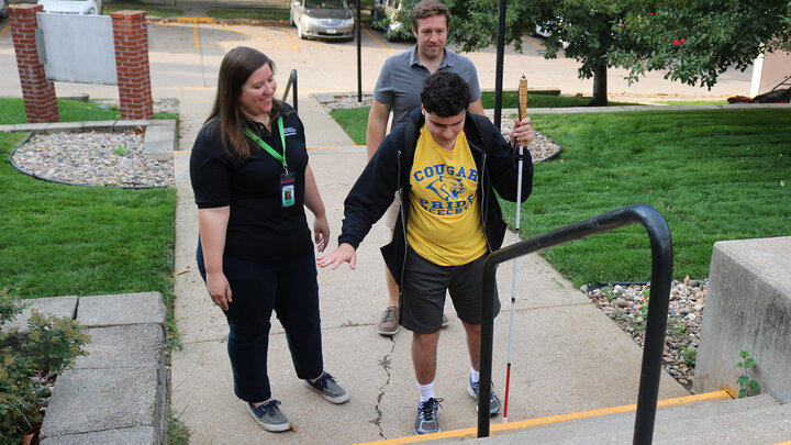 Person with visual impairment learning to navigate stairs.