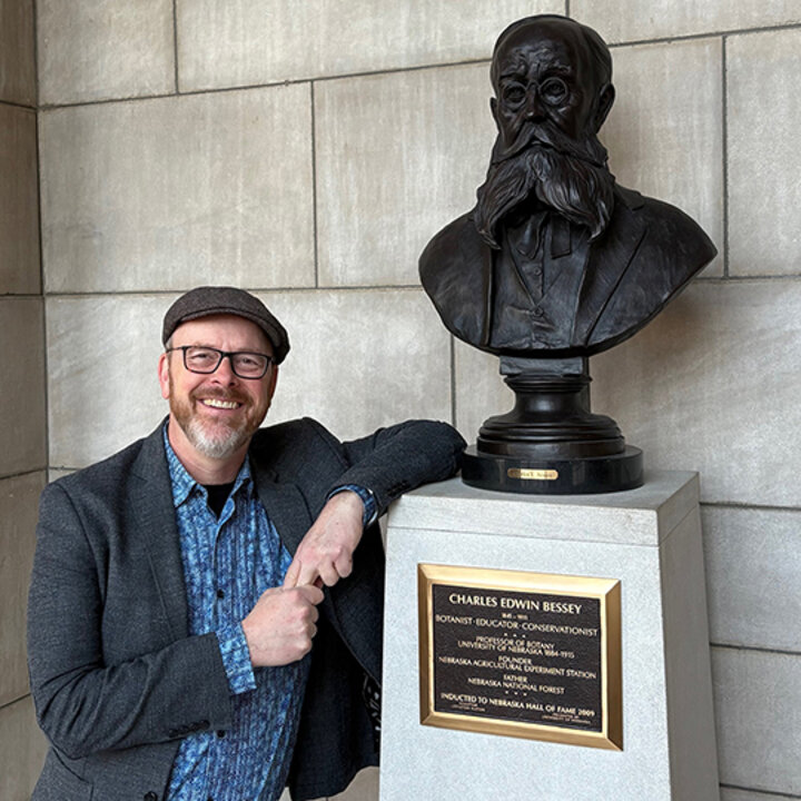 Ted Hamann poses with the sculpture for Charles Bessey at the Nebraska State Capitol
