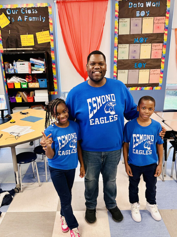 Jeremy Williams and two students in a group photo in his classroom