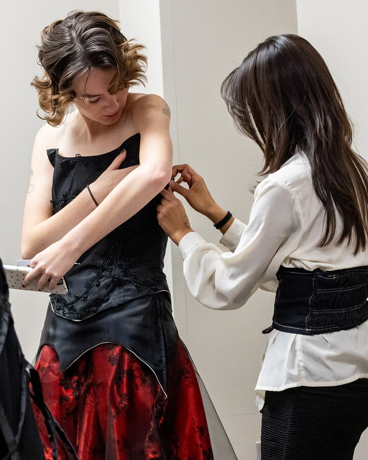 Jaquelyn Zavala Castro fits her dress on her model prior to the Project Funway fashion show