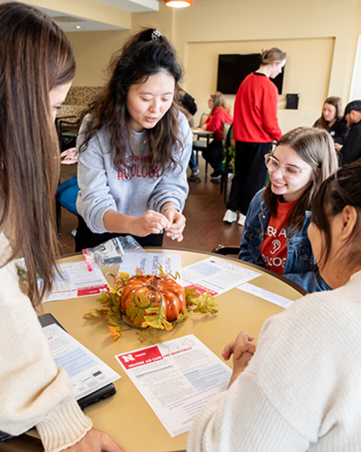 Eysl Behk demonstrates hearing aid care and cleaning to members of the Gateway Vista nursing staff while Emily Holt sits alongside her. (Loren Rye, Pixel Lab)