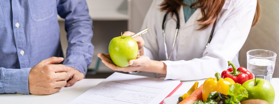 Two people with one holding a green apple.
