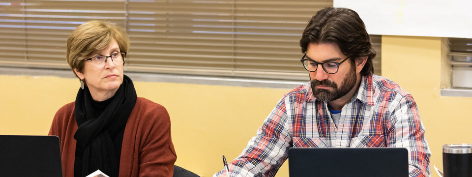 Two people sitting in meeting.