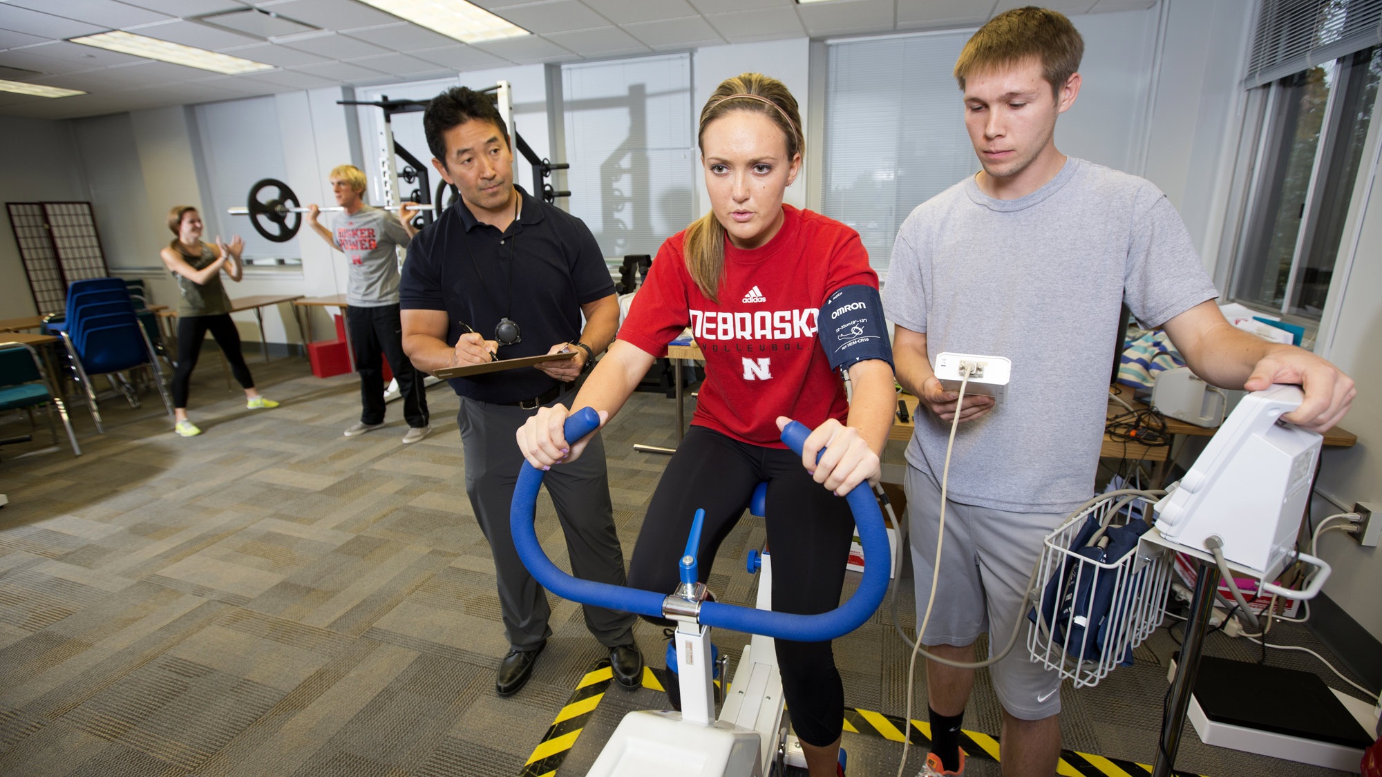 Student and coaches testing performance on an exercise bike.