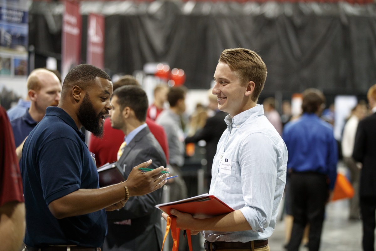 Photo of two young men having discussion at event.