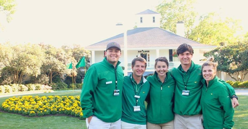 Student posing in front of clubhouse at Augusta Masters event.