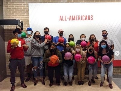 Group of people posing with their bowling balls.