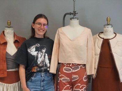Photo of Kelly next to clothing form.