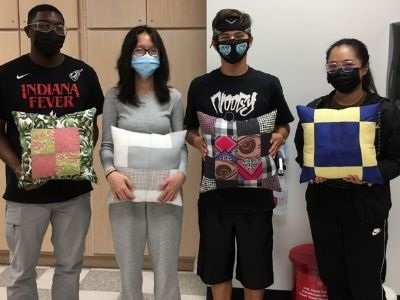 Group of students displaying their quilted pillows.