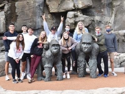 Group of students posing by gorilla sculptures.