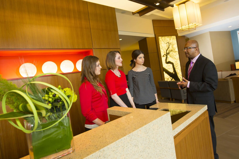 Dipra Jha with students examining hotel