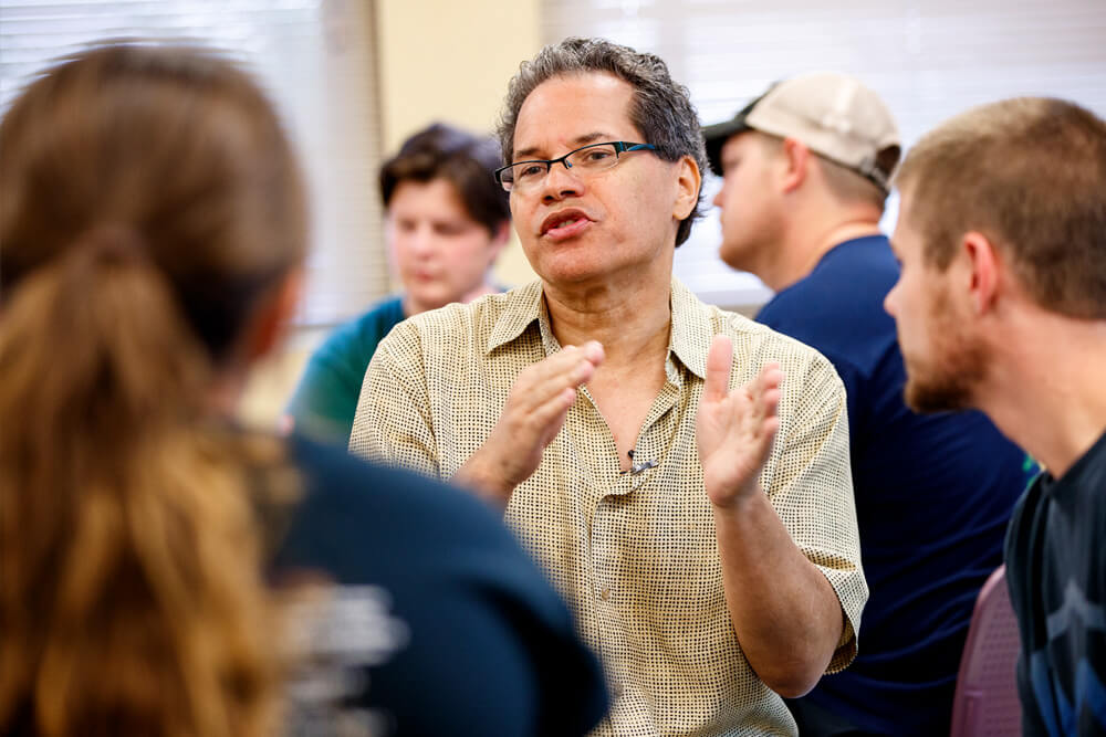 John Raible in classroom listening to student discussion